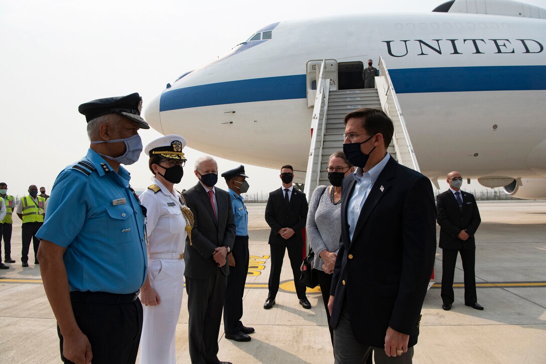 Defense Secretary Dr. Mark T. Esper speaks to people after getting off an airplane.