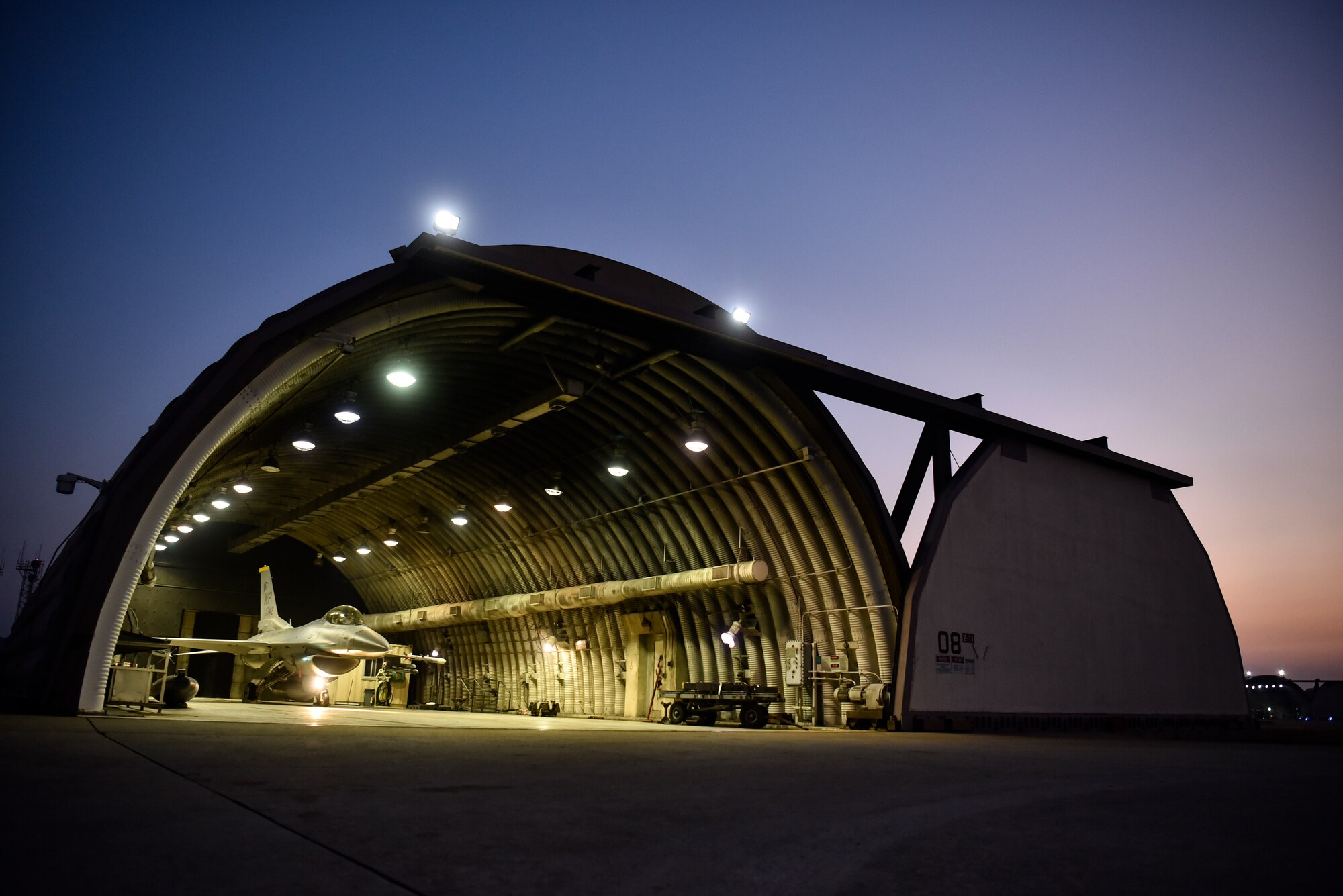 A photo of a fighter jet sitting in an aircraft hangar.