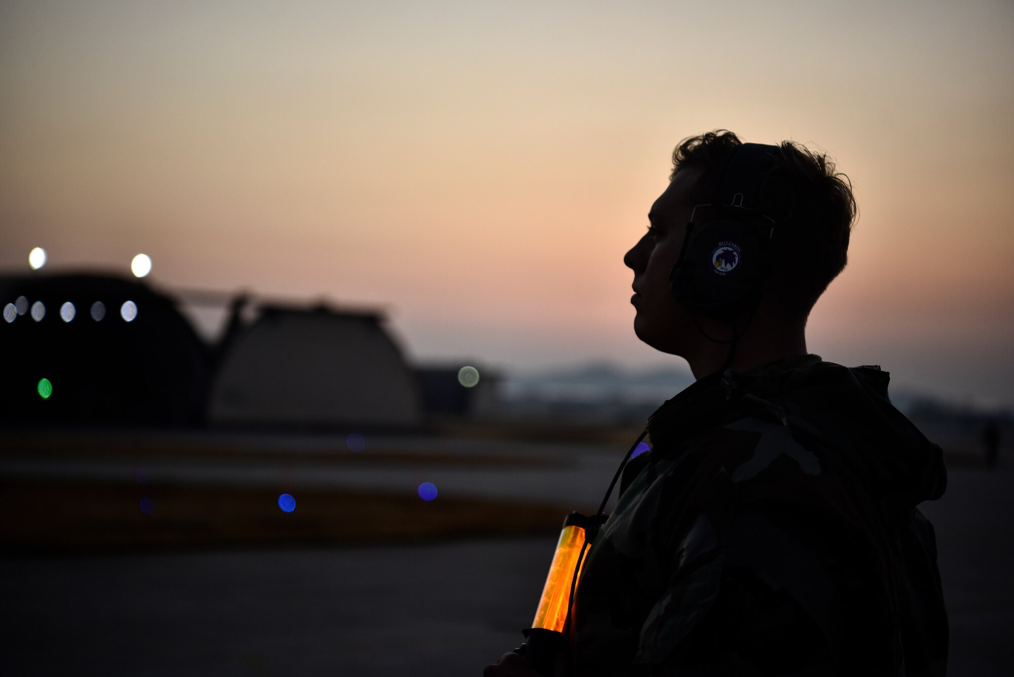 A photo of a crew chief standing on the flightline.
