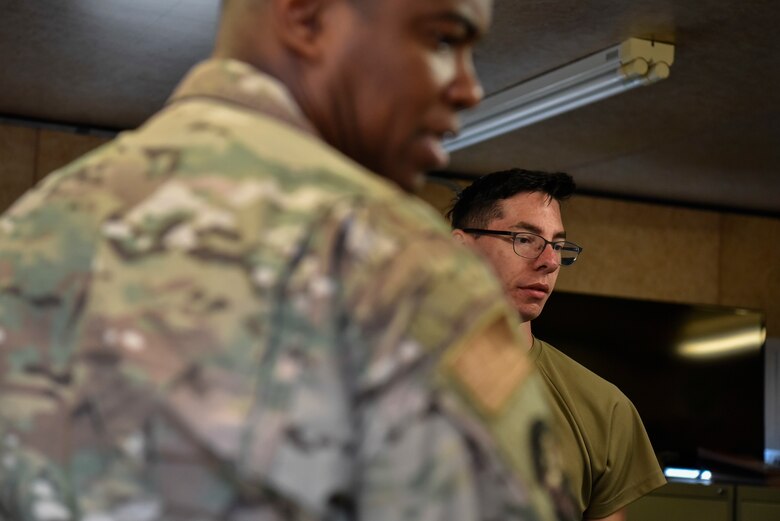 A photo of two Airmen discussing vehicle logistics.
