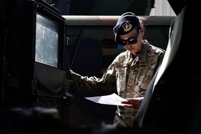 A photo of an Airman inspecting a Humvee.