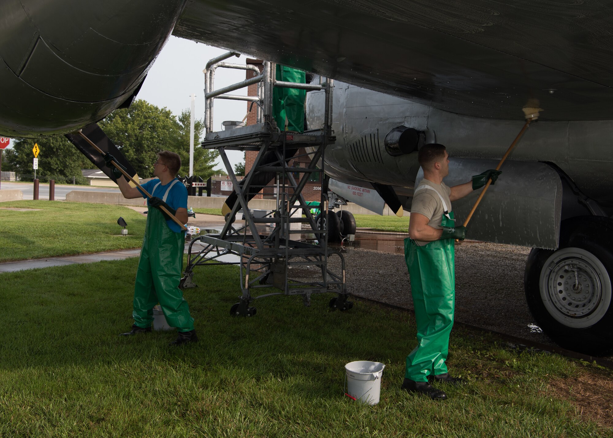Airmen scrub the underside of the left wing of a B-29 Superfortress.