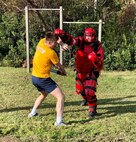 Intelligence Specialist 2nd Class Daniel Beckman engaged in hand-to-hand combat during the confidence course as part of Navy Expeditionary Intelligence Command’s Red Man training with Intelligence Specialist Clayton Bradley (red suit).
