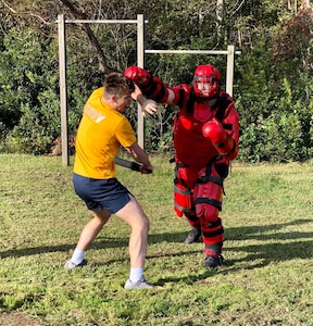 Intelligence Specialist 2nd Class Daniel Beckman engaged in hand-to-hand combat during the confidence course as part of Navy Expeditionary Intelligence Command’s Red Man training with Intelligence Specialist Clayton Bradley (red suit).