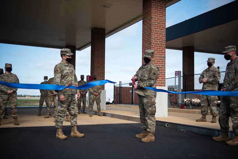 An Airman cuts the ribbon to open a new government vehicle fuel facility.