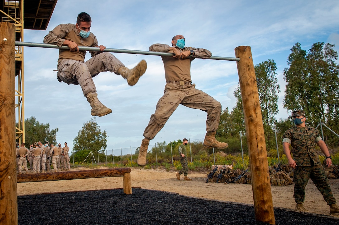U.S. Marines and sailors and European marines perform a pullup.