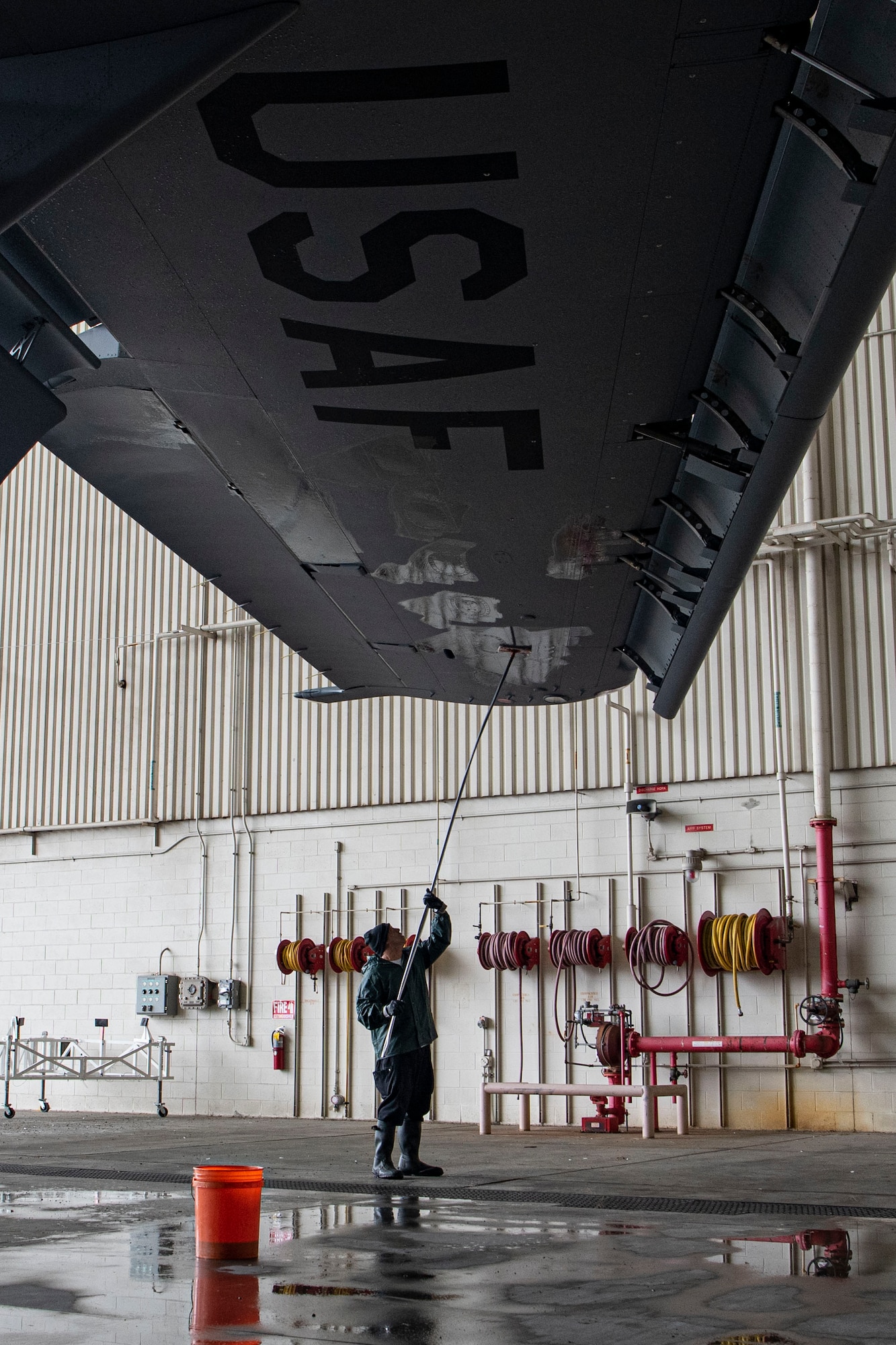Photo of an aircraft wash specialist cleaning the wing of a C-17 Globemaster III.