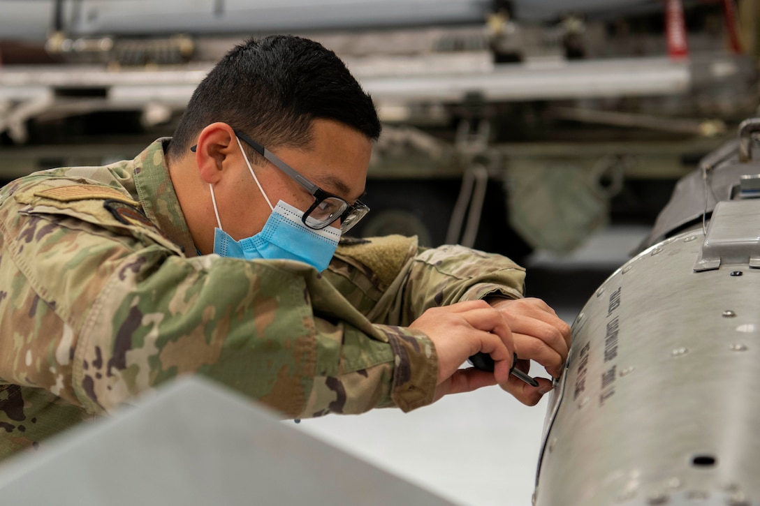 An airman works on a weapon.