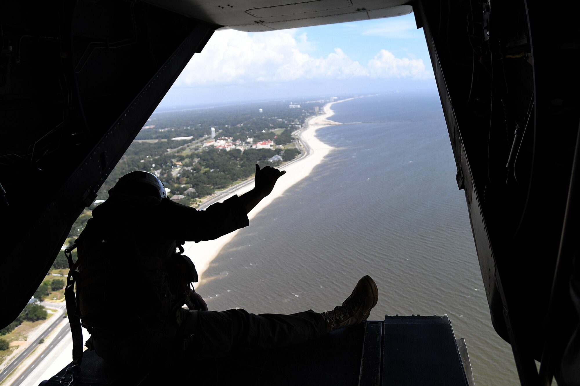 U.S. Marine Corps Staff Sgt. Jake Clark, Marine Medium Tiltrotor Squadron 774 MV-22B Osprey crew chief, Naval Air Station Norfolk, Virginia, sits on the back of an MV-22B Osprey over Gulfport, Mississippi, Oct. 23, 2020. Marines came to Keesler to conduct routine training operations in and around the Mississippi area. (U.S. Air Force photo by Senior Airman Suzie Plotnikov)