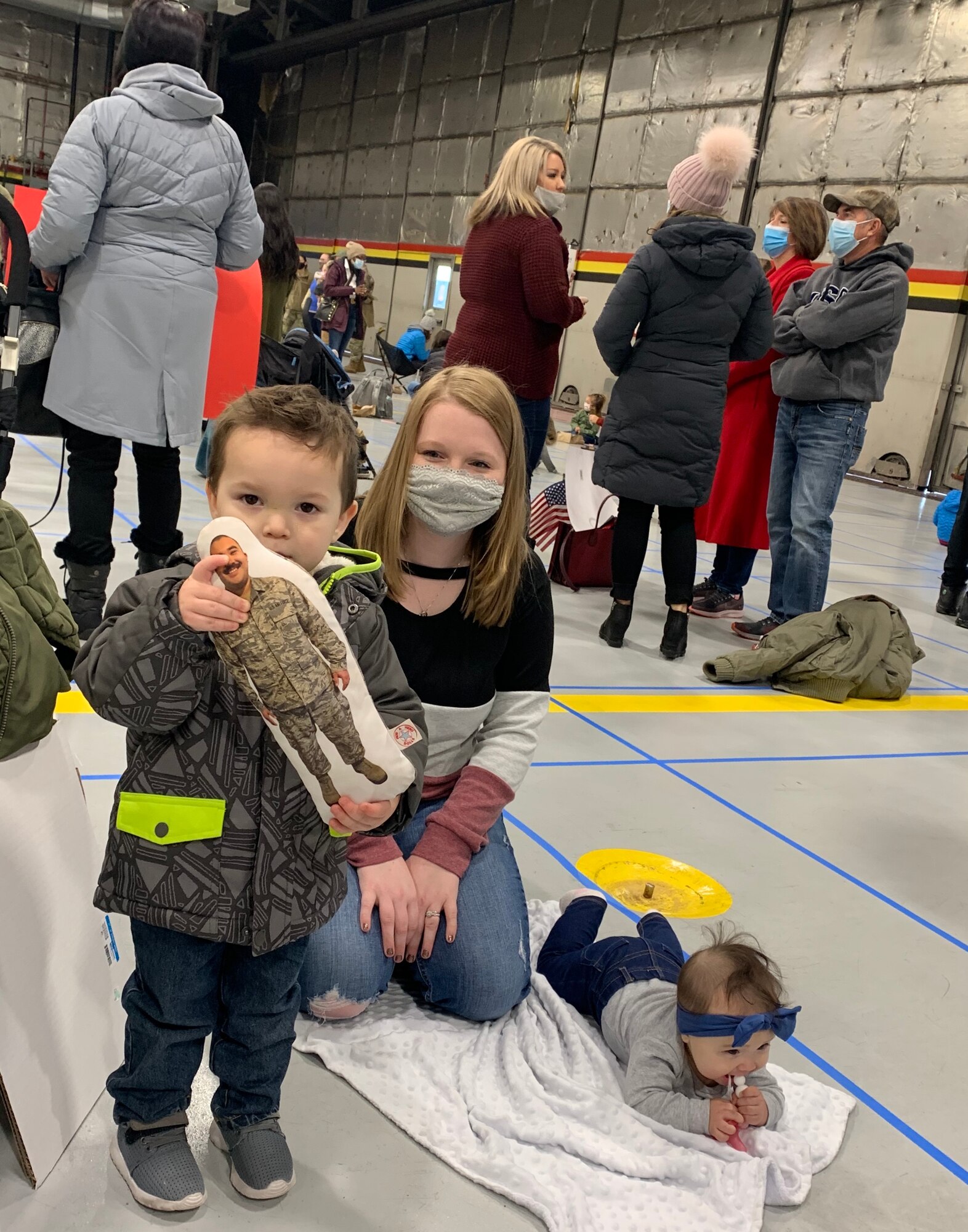 Sydney Rondeau has her hands full with son, Dawson, age 2, and 7-month-old daughter, Ava, as they patiently await the arrival of Staff Sgt. Jevon Rondeau, who returned home Sunday following a deployment to Al Dhafra Air Base, United Arab Emirates.