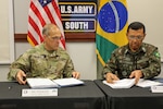 Maj. Gen. Daniel R. Walrath (left), U.S. Army South commanding general, and General de Brigada Otávio Rodrigues de Miranda Filho, 5th deputy chief of staff for the Brazilian Army, sign documents to approve agreed-to-actions and a five year plan between the two armies to conclude the U.S., Brazil army-to-army staff talks at Army South headquarters at Joint Base San Antonio-Fort Sam Houston Oct. 23.