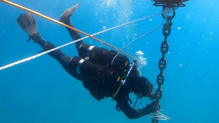 Builder 2nd Class Christian Makin, assigned to Underwater Construction Team TWO (UCT 2) Construction Diving Detachment Charlie (CDD/C) places explosives on the riser chain of a training buoy off the coast of San Clemente Island, Calif.