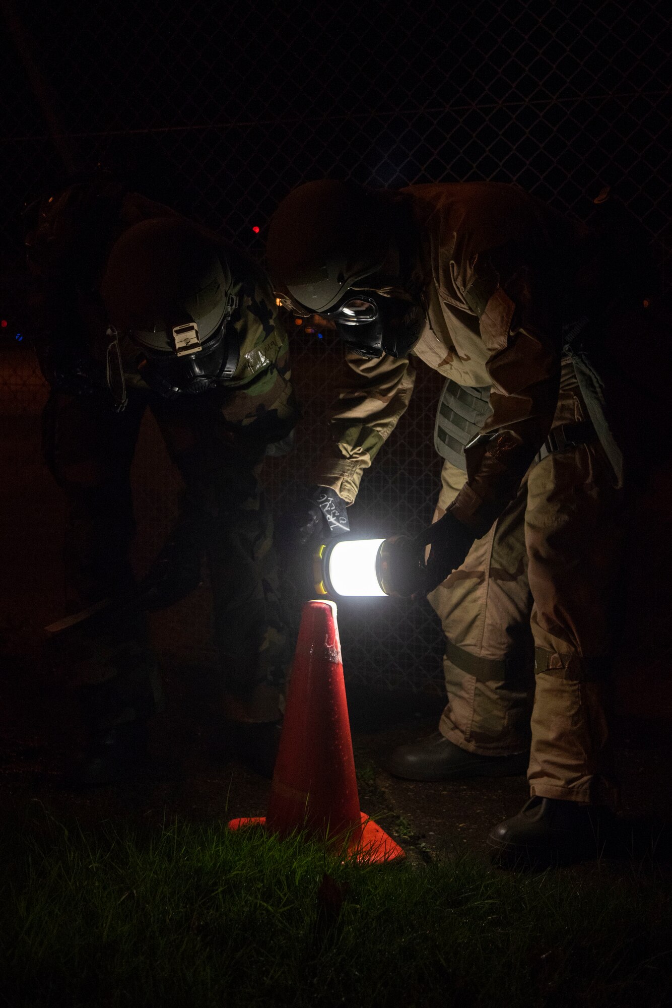 U.S. Air Force Staff Sgt. Joseph Johnson, 727th Air Mobility Squadron special handling shift supervisor, left, and Airman 1st Class Roberto Martinez, 727th AMS air terminal operations center information controller, right, examine M8 detection paper for the presence of contaminants during exercise Nodal Lightning at Royal Air Force Mildenhall, England, Oct. 21, 2020. The 727th AMS demonstrated their flexibility by responding to a contingency scenario while sustaining operations continuity around the clock. (U.S. Air Force photo by Airman 1st Class Joseph Barron)