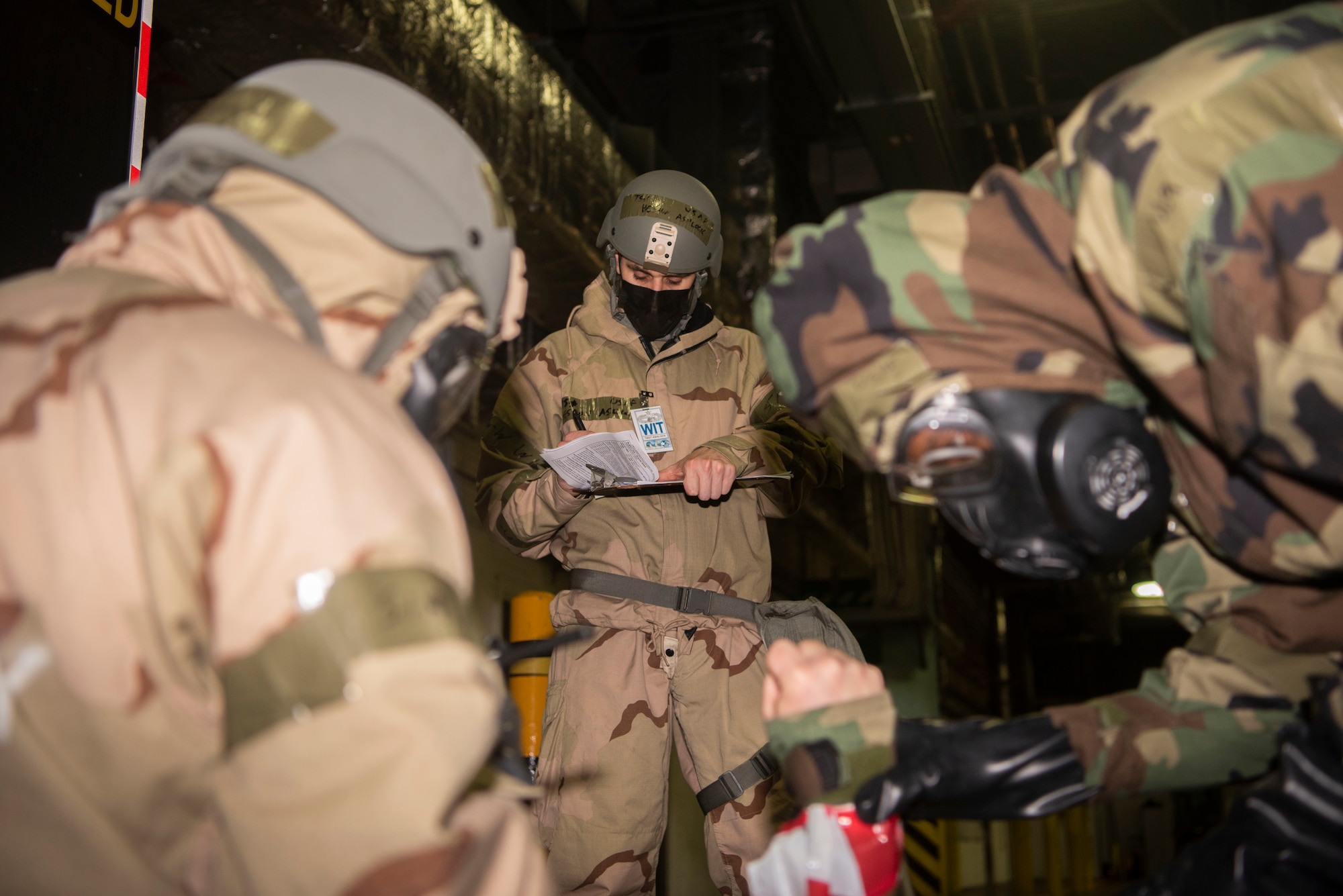 U.S. Air Force Tech. Sgt. Heston Ashlock, 727th Air Mobility Squadron wing inspection team member, records his observations while 727th AMS Airmen perform self-aid buddy care on a simulated injury during exercise Nodal Lightning at Royal Air Force Mildenhall, England, Oct. 21, 2020. The 727th AMS, and parent unit 521st Air Mobility Operations Wing, Ramstein Air Base, Germany, are key nodes in delivering rapid global air mobility in support of the national defense strategy. (U.S. Air Force photo by Airman 1st Class Joseph Barron)