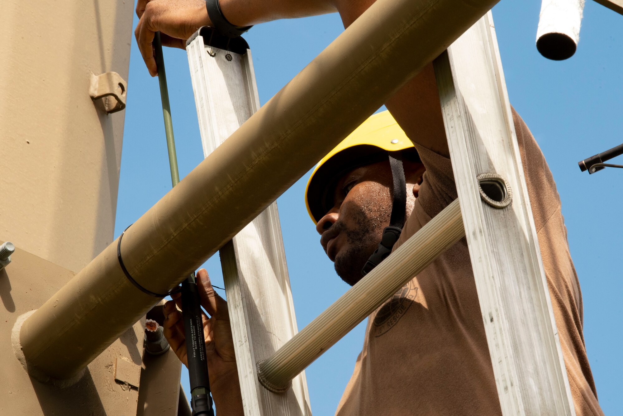 A photo of an Airman preparing to install a high-frequency antenna.