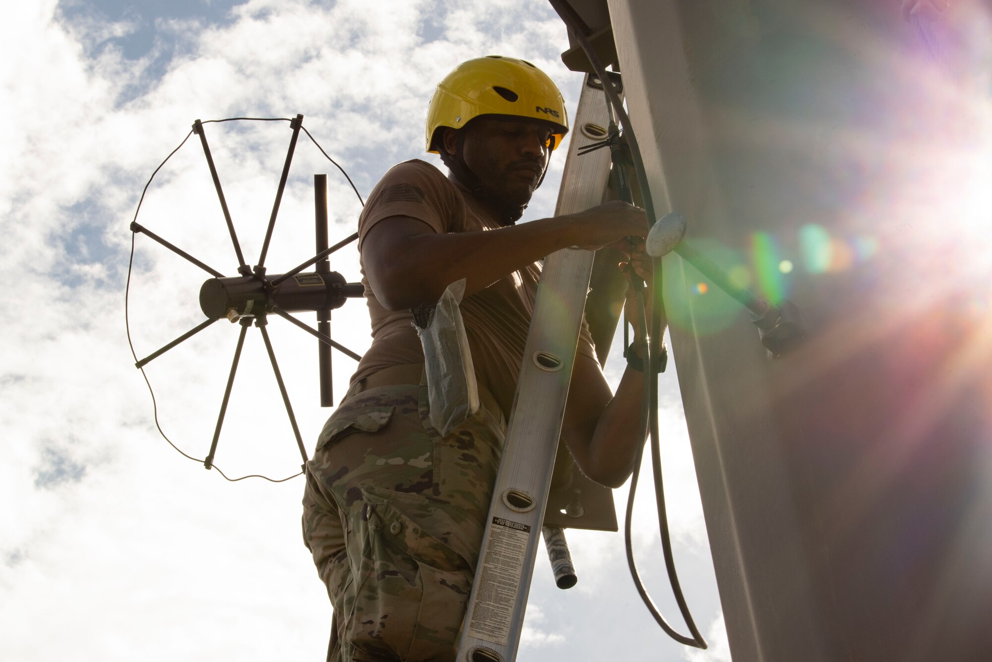 A photo of an Airman installing a high-frequency antenna.