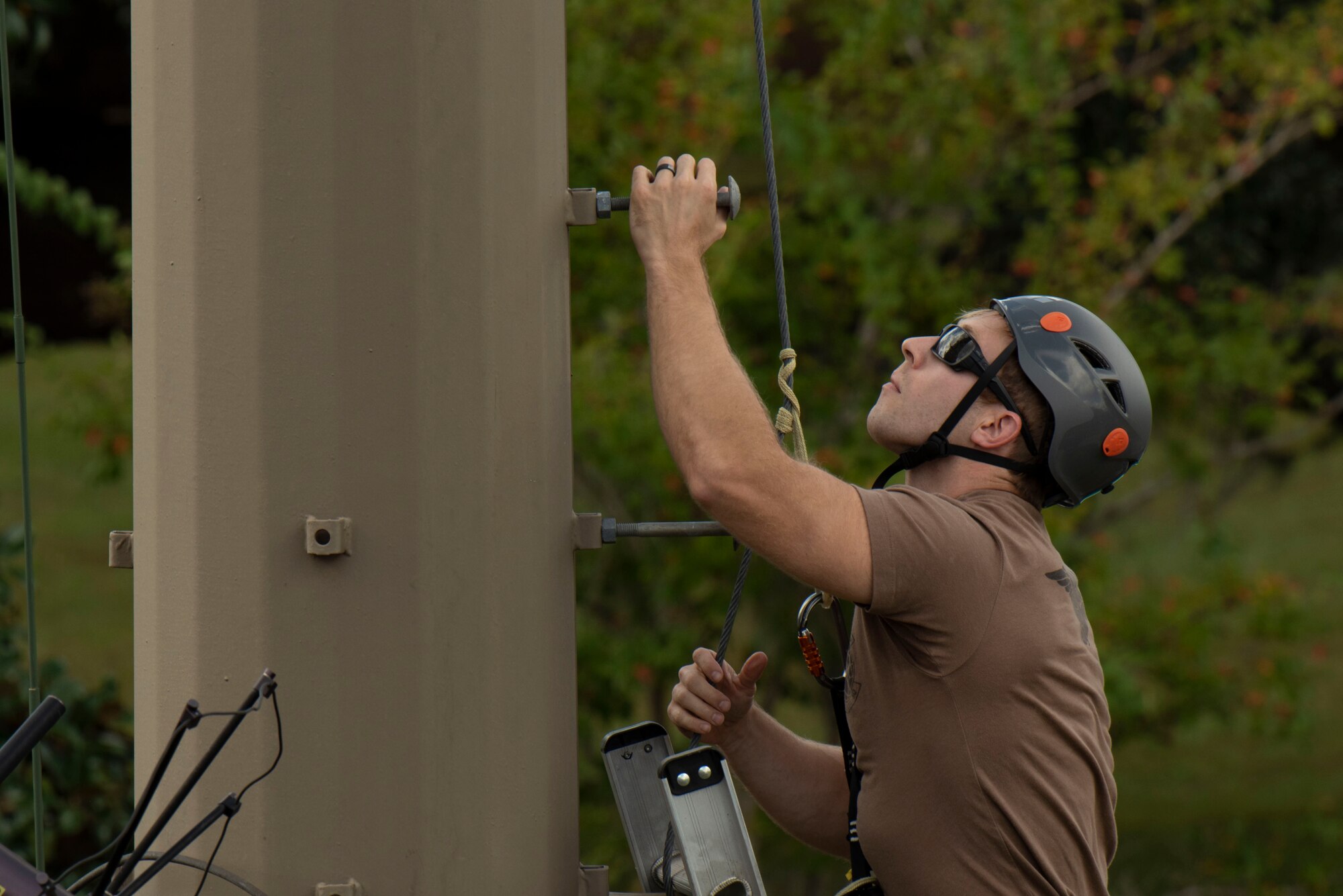 A photo of an Airman climbing a communications tower.