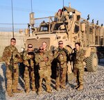 Members of BEST A24 stand next to an MRAP in Afghanistan.