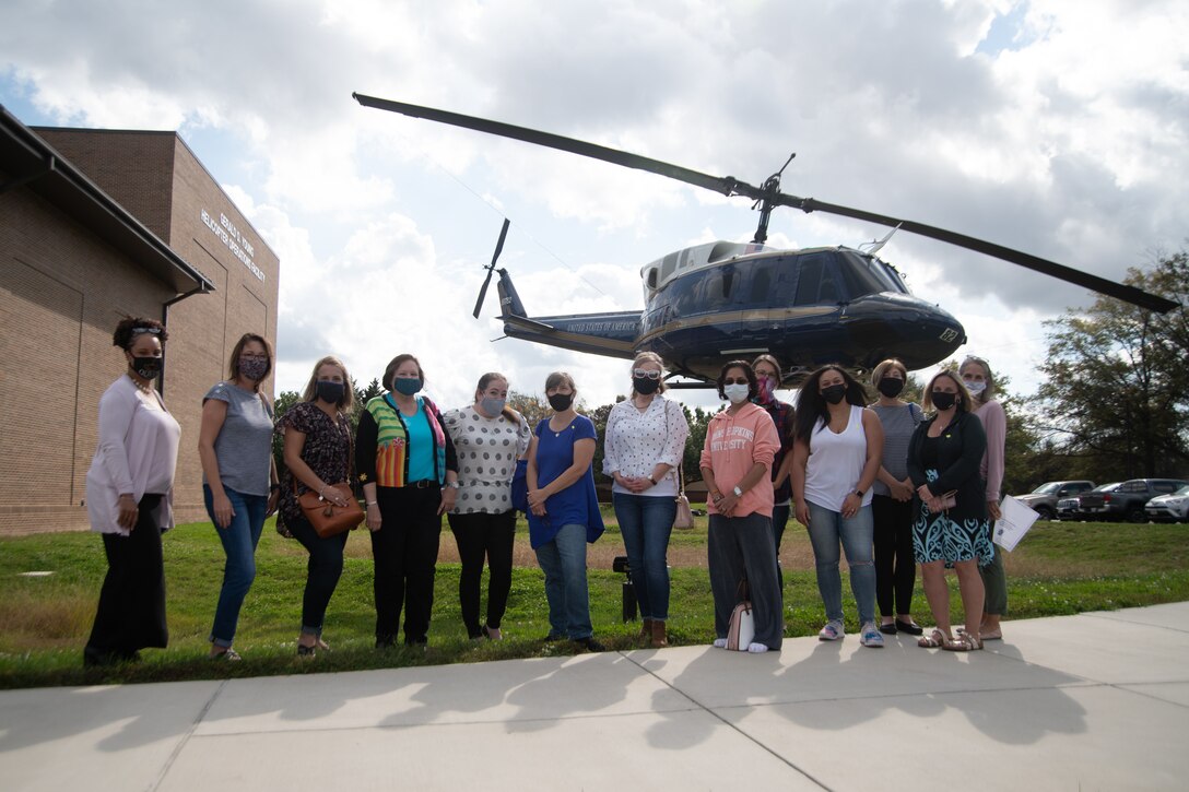 Joint Base Andrews military spouses and tour guides pose for a photo in front of the Helicopter Operations Facility during JBA’s first “Windshield Tour,” a quarterly event hosted by the Military and Family Support Center that provides introductions to historical attractions on the base, Oct. 23, 2020.