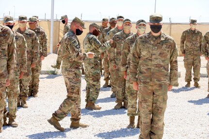 Senior non-commissioned officers with Headquarters and Headquarters Company, 2nd Battalion, 130th Infantry Regiment, based in Marion, Illinois, present the Soldiers with combat patches.