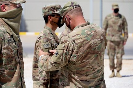 Command Sgt. Maj. Jeffery Sowash, of Springfield, Missouri, 2nd Battalion, 130th Infantry Regiment’s senior enlisted leader, presents 1st Lt. Mike Ferrer, of Fairview Heights, Illinois, with his combat patch which will be displayed on his right shoulder.