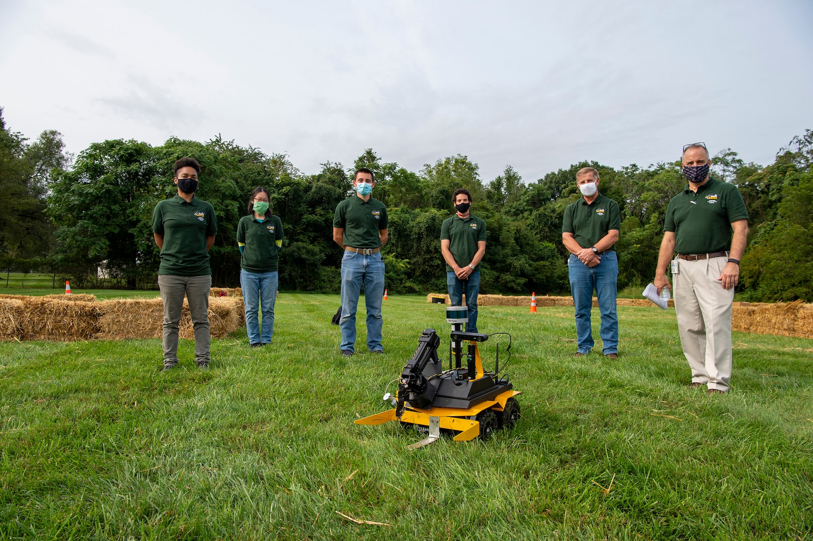 Engineers Stephanie Blease, Mei Ling McAfee and Isaac Downey stand with their Team Mentor Benjamin Gordon, Marine Corps Vulnerability and Protection Manager Rodney Peterson and Technical Director Larry Tarasek before competing in the TD Cup.