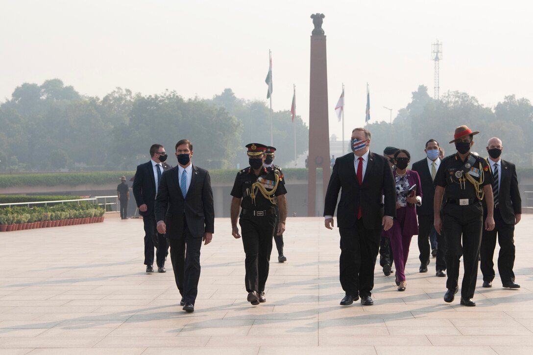 Defense Secretary Dr. Mark T. Esper and Secretary of State Michael R. Pompeo walk with other officials at an outdoor monument.