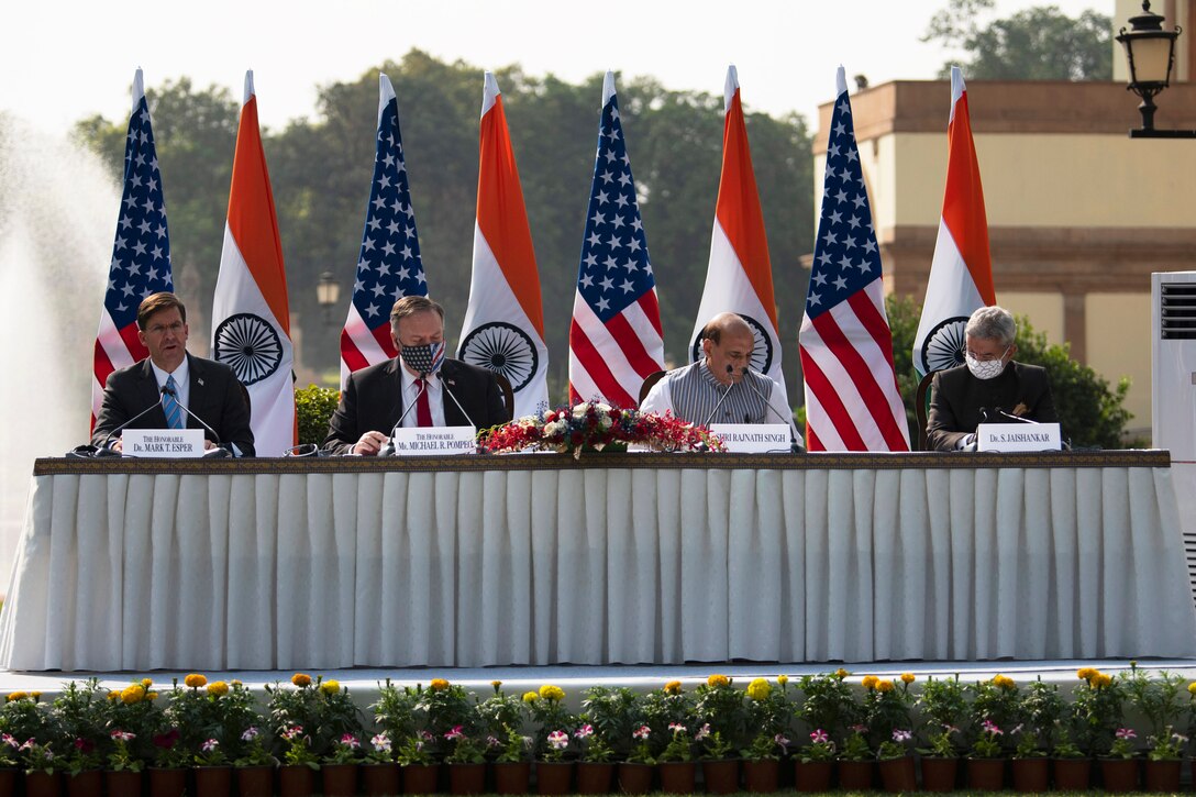 Defense Secretary Dr. Mark T. Esper and Secretary of State Michael R. Pompeo sit at a long table outdoors with their Indian counterparts.