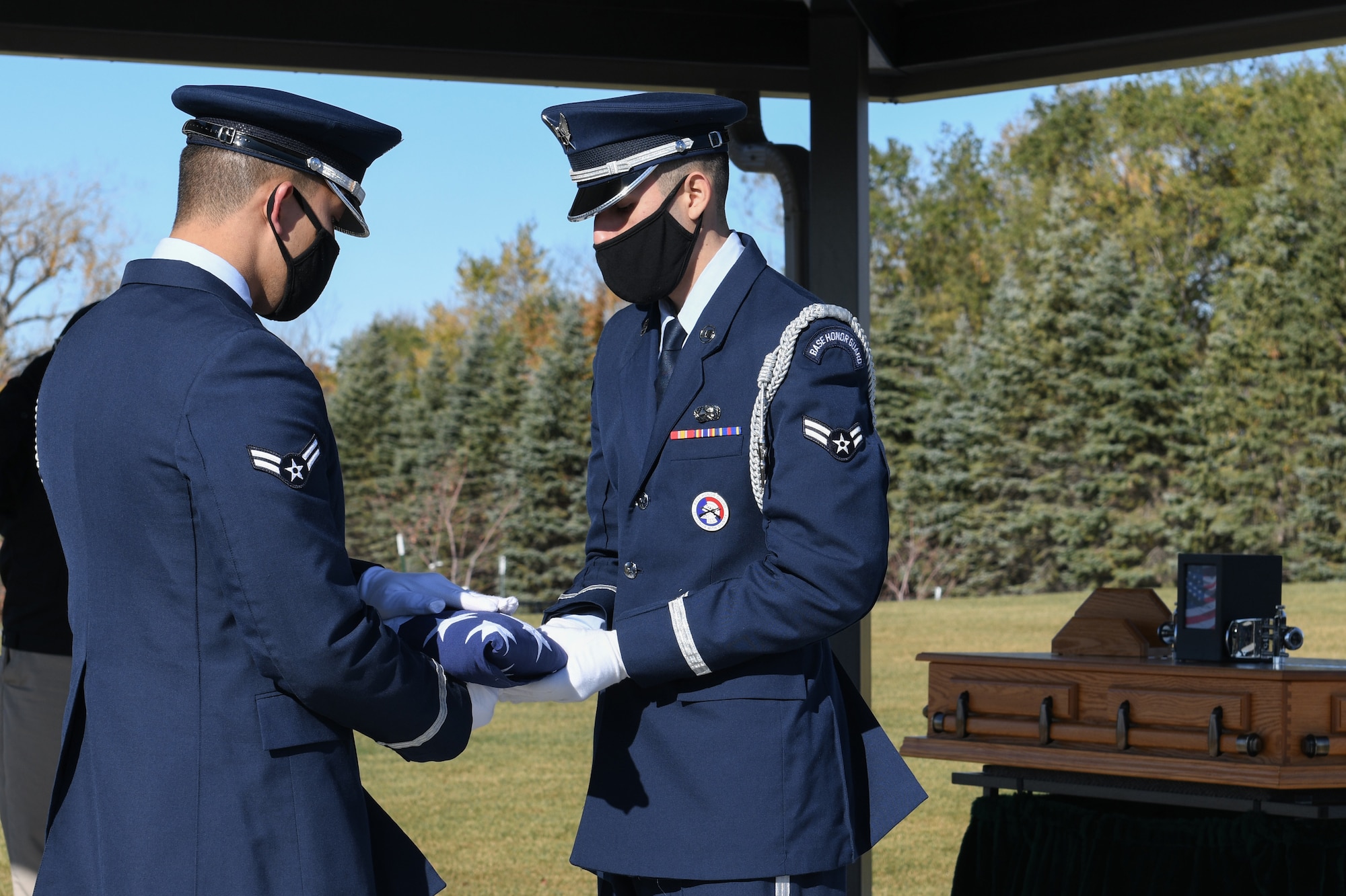 Two honor guardsmen from Grand Forks Air Force Base fold the flag during a funeral service for an unclaimed veteran Oct. 16, 2020 at the Fargo National Cemetary, N.D. Lelan Arthur Derr, Iowa native, and United Stated Air Force veteran who served in the Vietnam War era between 1971 and 1975, died December 10, 2019. (U.S. Air Force photo by Airman Ashley Richards)