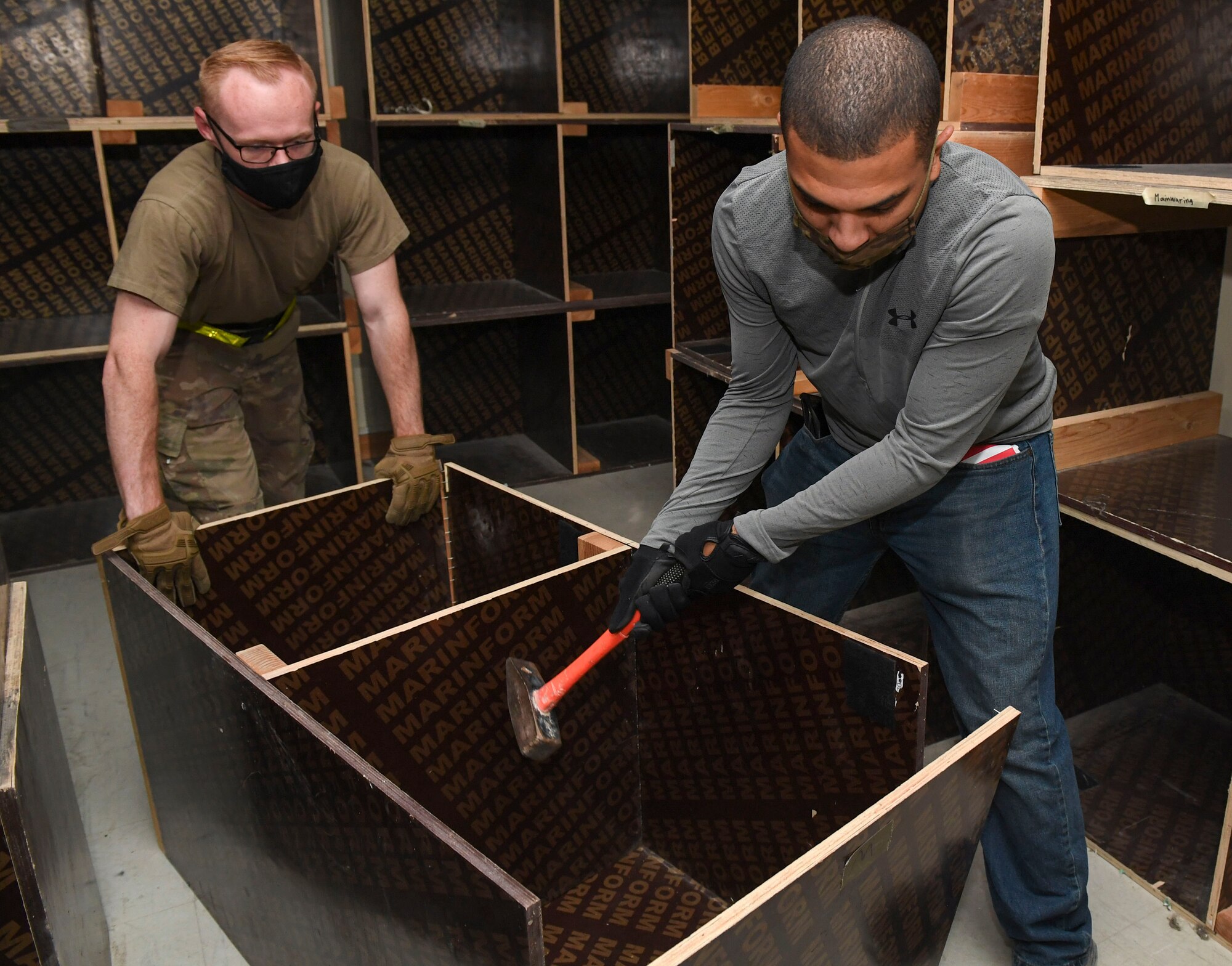 U.S. Air Force Senior Airman Thomas Heatherdale, 386th Expeditionary Maintenance Squadron munitions crew chief, and Senior Airman William Parker, 386th Air Expeditionary Wing Financial Management military pay technician, break a shelf during a demolition day at Ali Al Salem Air Base, Kuwait, Oct. 21, 2020.