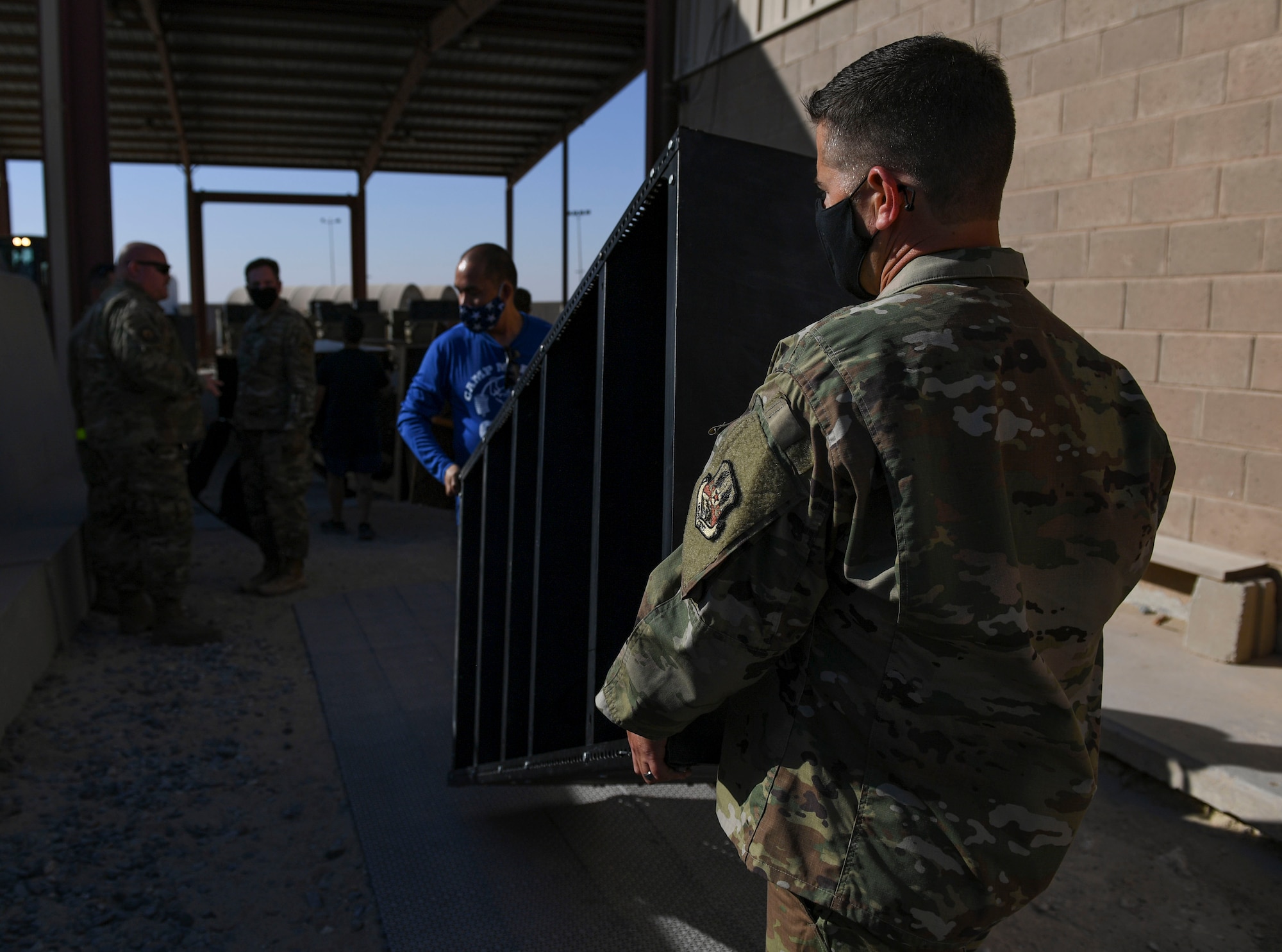 Demolition day volunteers carry a shelf at Ali Al Salem Air Base, Kuwait, Oct. 21, 2020.