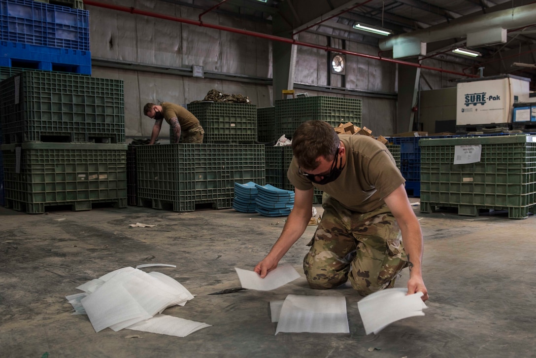 U.S. Air Force Airman 1st Class Bradan Phelps, 380th Expeditionary Logistics Readiness Squadron supply technician, and Senior Airman Collin Leger, 380th Expeditionary Logistics Readiness Squadron materiel management specialist, stow ballistic plates at the individual protective equipment (IPE) warehouse on Al Dhafra Air Base, United Arab Emirates, Oct. 27, 2020.