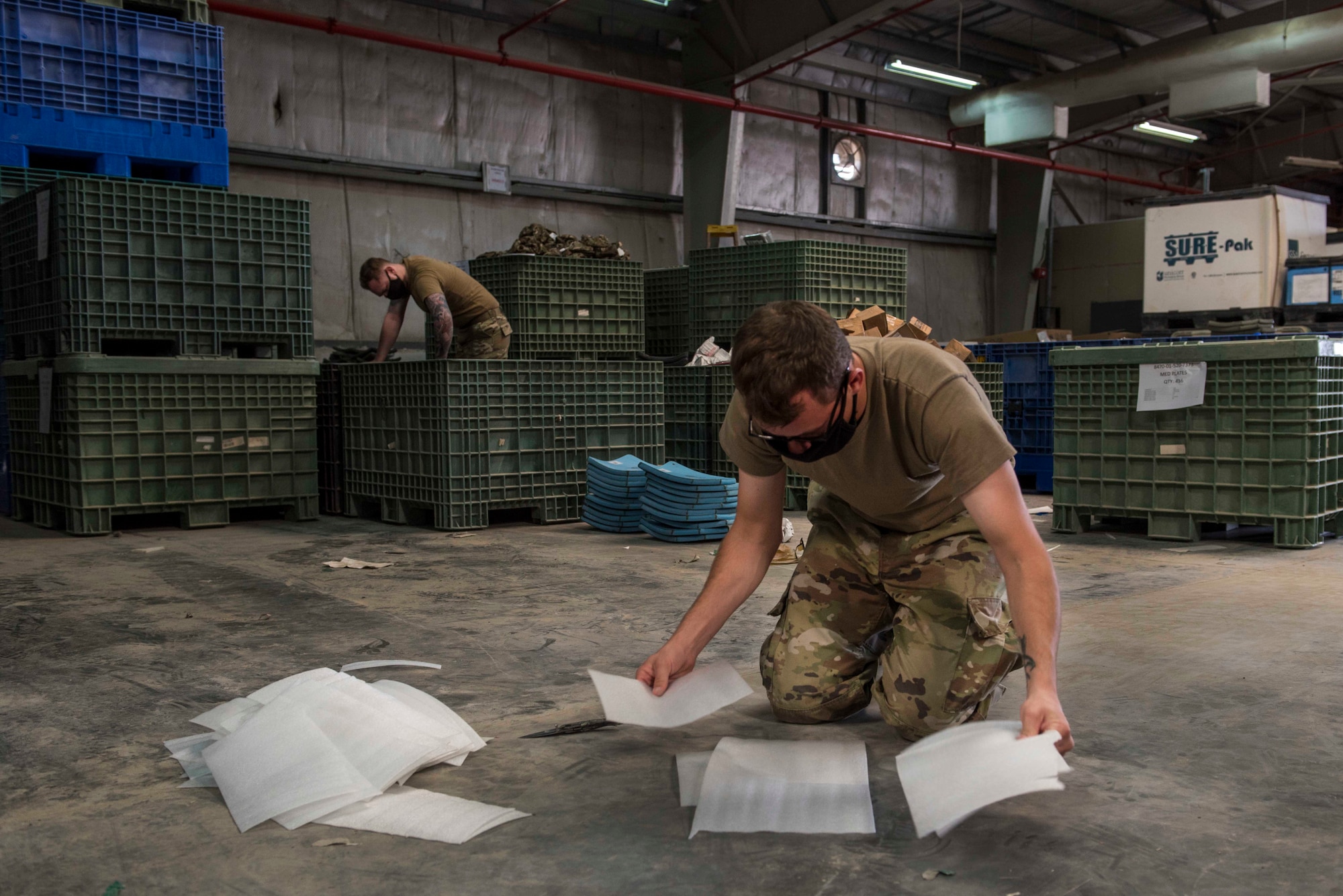 U.S. Air Force Airman 1st Class Bradan Phelps, 380th Expeditionary Logistics Readiness Squadron supply technician, and Senior Airman Collin Leger, 380th Expeditionary Logistics Readiness Squadron materiel management specialist, stow ballistic plates at the individual protective equipment (IPE) warehouse on Al Dhafra Air Base, United Arab Emirates, Oct. 27, 2020.