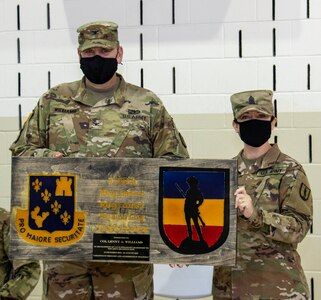 Command Sgt. Major Mary Dixon, of Chapin, Illinois, Commandant, 129th Regiment (RTI), based in Springfield, Illinois, presents Col. Lenny Williams, of Dyer, Indiana, with a gift from the Regiment during a change of command ceremony Aug. 23 at the Illinois Military Academy, Camp Lincoln, Springfield, Illinois.