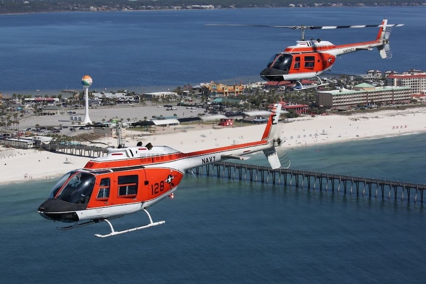 Two U.S. Navy TH-57C Sea Ranger helicopters conduct a formation training flight over Pensacola Beach, Fla.