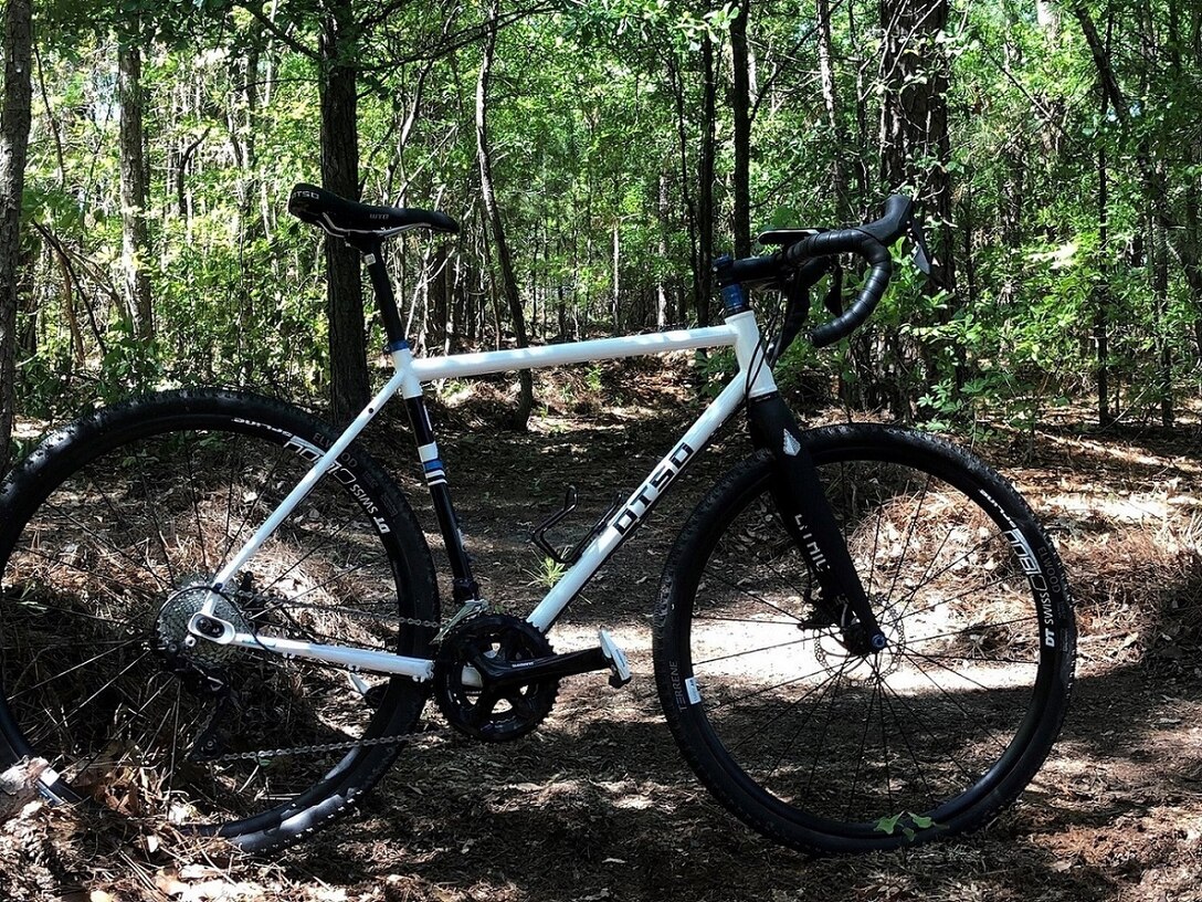 A mountain bike stands on a trail in the woods.