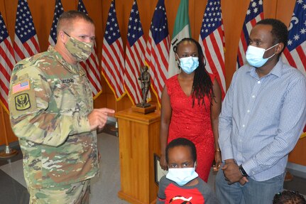 North Carolina National Guard (NCNG) Army Brig. Gen. Jeffrey L. Copeland, left, assistant adjutant general, sustainment, congratulates Gladys Ngari and her family on her becoming the NCNG Employment Center's 3,000th hire at a ceremony at NCNG Joint Force Headquarters in Raleigh, North Carolina, Oct. 19, 2020. Ngari's husband, right, is NCNG Army 1st Lt. Joseph Muraguri.