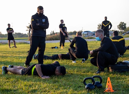 Sgt. 1st Class Joseph Thomas, Non-commissioned Officer in Charge of the Army Combat Fitness Test (ACFT) training team from Fort Eustis, Virginia, talks to Illinois Army National Guard Soldiers conducting the hand release push-ups