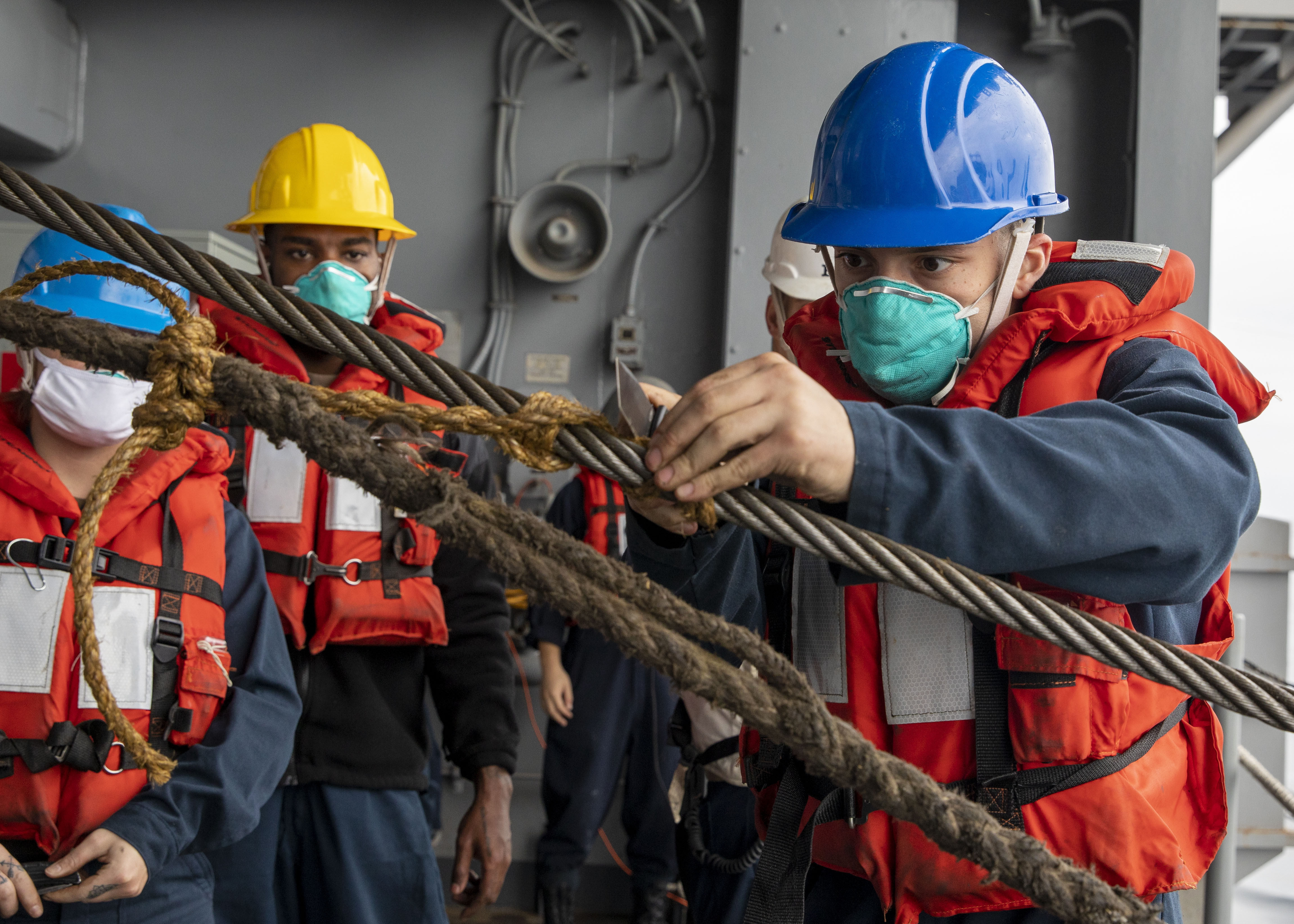 Boatswain’s Mate 3rd Class Anthony Arlotta cuts a line during a replenishment-at-sea with fleet replenishment oiler USNS Guadalupe (T-AO 200) aboard the amphibious assault ship USS Makin Island (LHD 8).