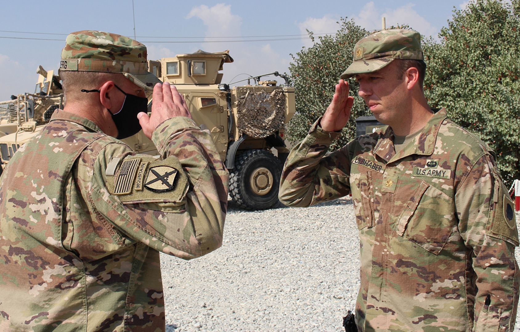 Maj. Scott Liebhaber, of Chicago, salutes Lt. Col. Jason Osberg, of Champaign, Illinois, Commander, Bilateral Embedded Staff Team A25, following the presentation of Osberg’s combat patch.