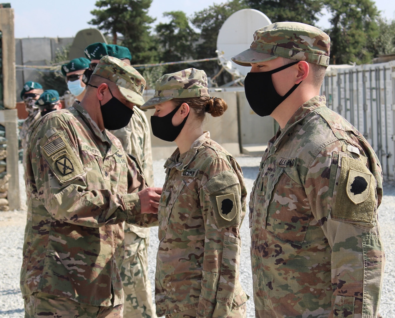 Lt. Col. Jason Osberg, of Champaign, Illinois, Commander, Bilateral Embedded Staff Team A25, presents Maj. Lorrie Novak, of Frankfort, Illinois, with her combat patch during the recent ceremony.