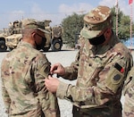 Lt. Col. Jason Osberg, of Champaign, Illinois, Commander, Bilateral Embedded Staff Team A25, presents Master Sgt. Adam Abdul, of Collinsville, Illinois, with his combat patch during the recent ceremony.