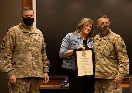 Angie Jiannoni, wife of Lt. Col. Jeffary Jiannoni, of Petersburg, Illinois, accepts a Certificate of Appreciation from Col. Leonard Williams, of Dyer, Indiana, Chief of Staff, Illinois Army National Guard, during Jiannoni’s retirement ceremony Oct. 8 at the Illinois Military Academy, Camp Lincoln, Springfield, Illinois.