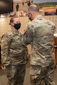 Newly promoted Sgt. 1st Class Lindsey Gibbs, of Pleasant Plains, Illinois, is presented with an Army Commendation Medal from Col. Daniel Reichen, of Springfield, Illinois, military personnel officer for the Illinois Army National Guard during Gibbs’ promotion ceremony at the Illinois Military Academy, Camp Lincoln, Springfield, Illinois Oct. 15.