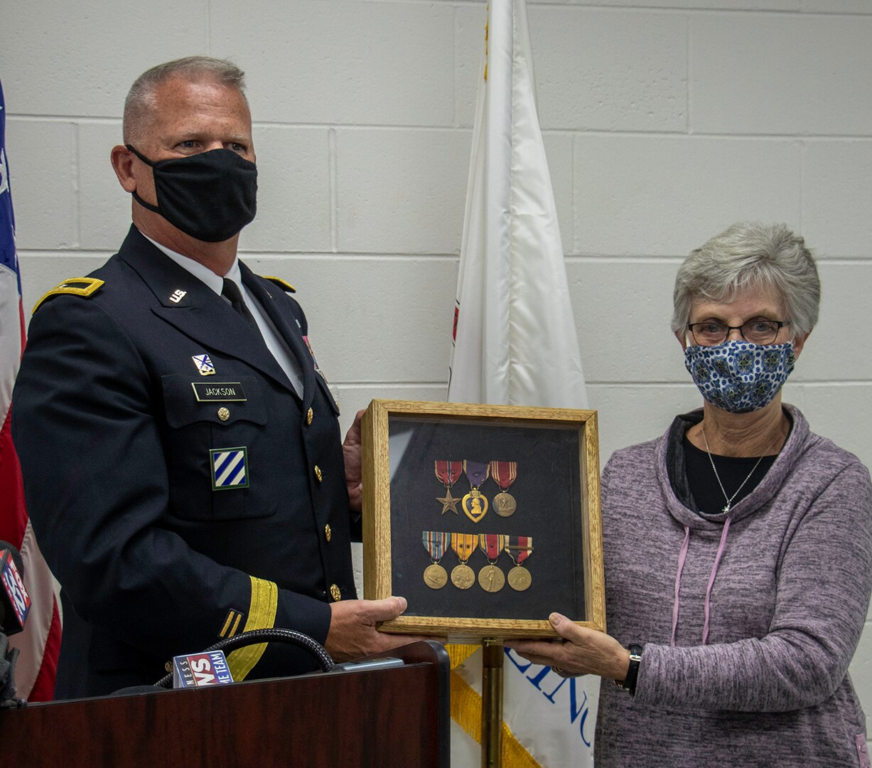 Kathy Andersen, of Roscoe, Illinois, great niece of the late Homer Stanger, accepts Stanger’s returned medals