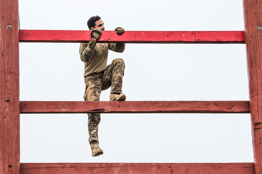 An airman climbs a large ladder.