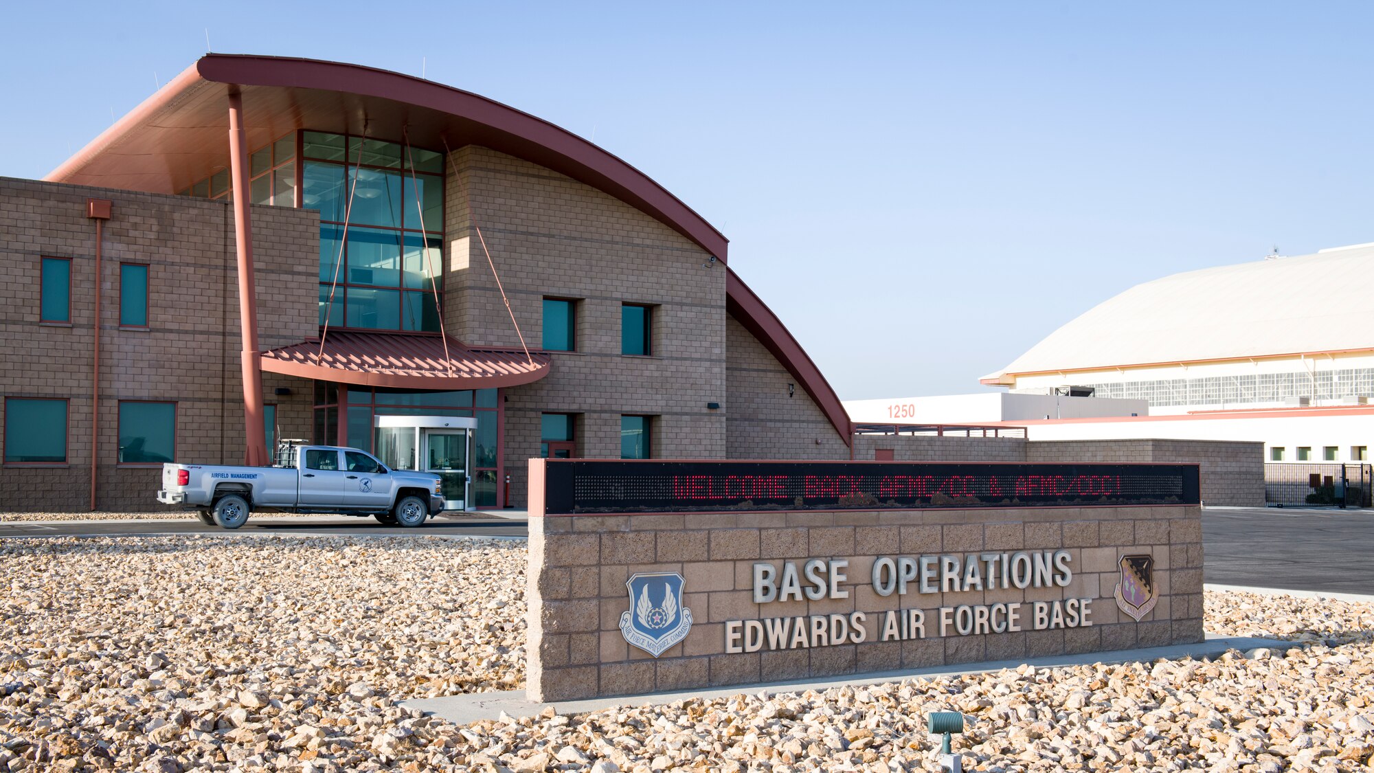 The Base Operations building welcomes Gen. Arnold W. Bunch, Jr., commander of Air Force Materiel Command, and Chief Master Sgt. Stanley Cadell, AFMC Command Chief, to Edwards Air Force Base, California, Oct. 23. (Air Force photo by Giancarlo Casem)