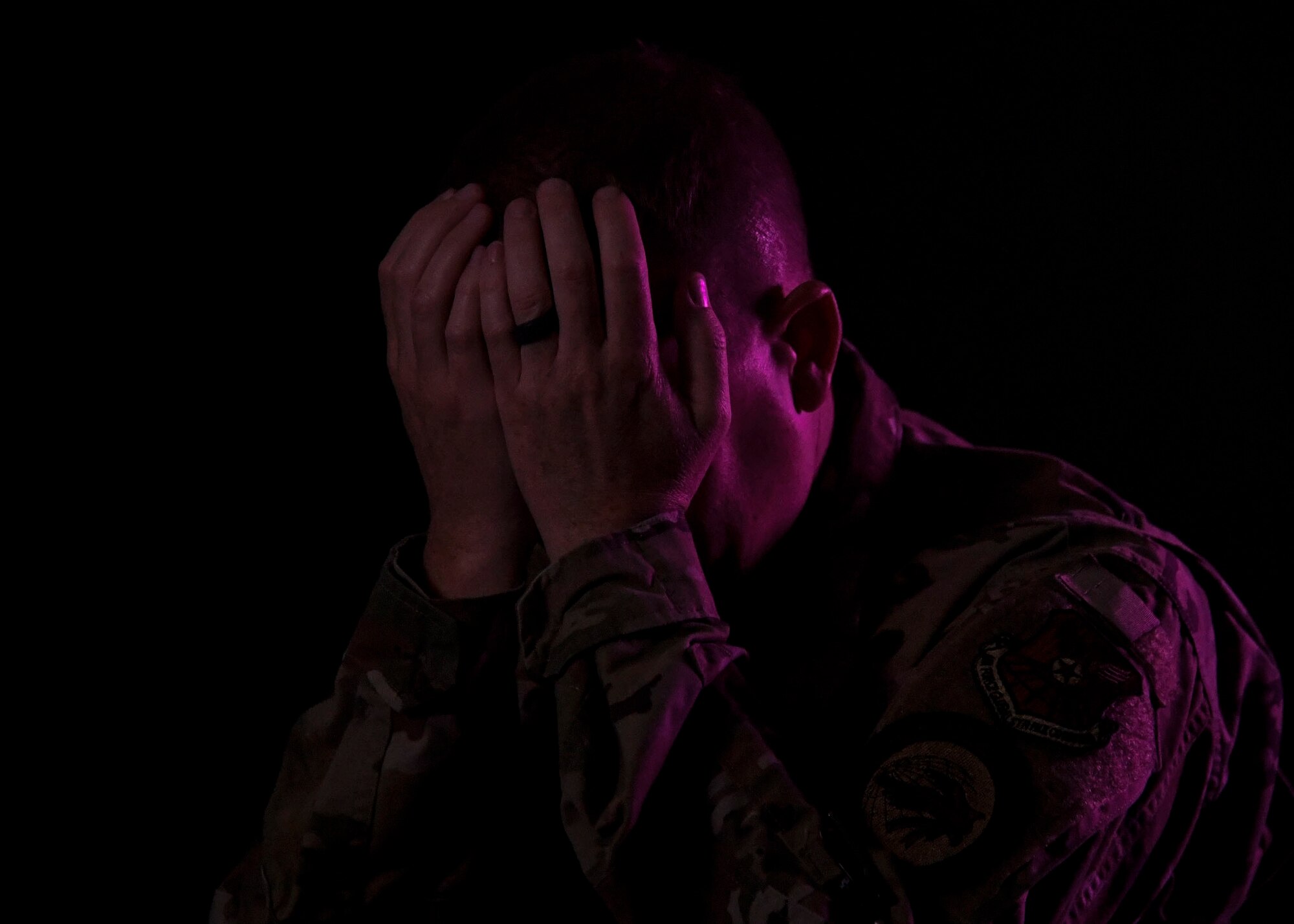 Man poses with his face in his palms