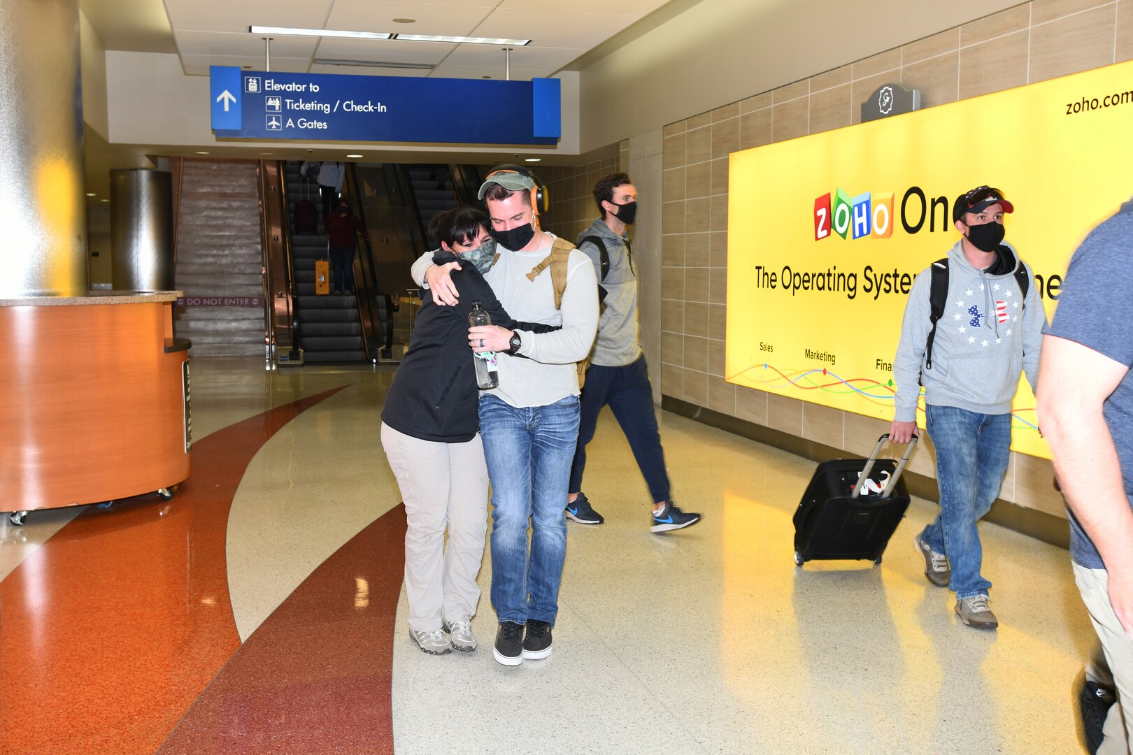 Master Sgt. Justin W. Meece, 433rd Security Forces Squadron, is embraced by his wife, Rebecca Archuleta, upon arrival at the San Antonio International Airport Oct. 26, 2020. Meece, along with 12 additional Reserve Citizen Airmen arrive home after a three month long deployment to Southwest Asia. (U.S. Air Force photo by Master Sgt. Kristian Carter)