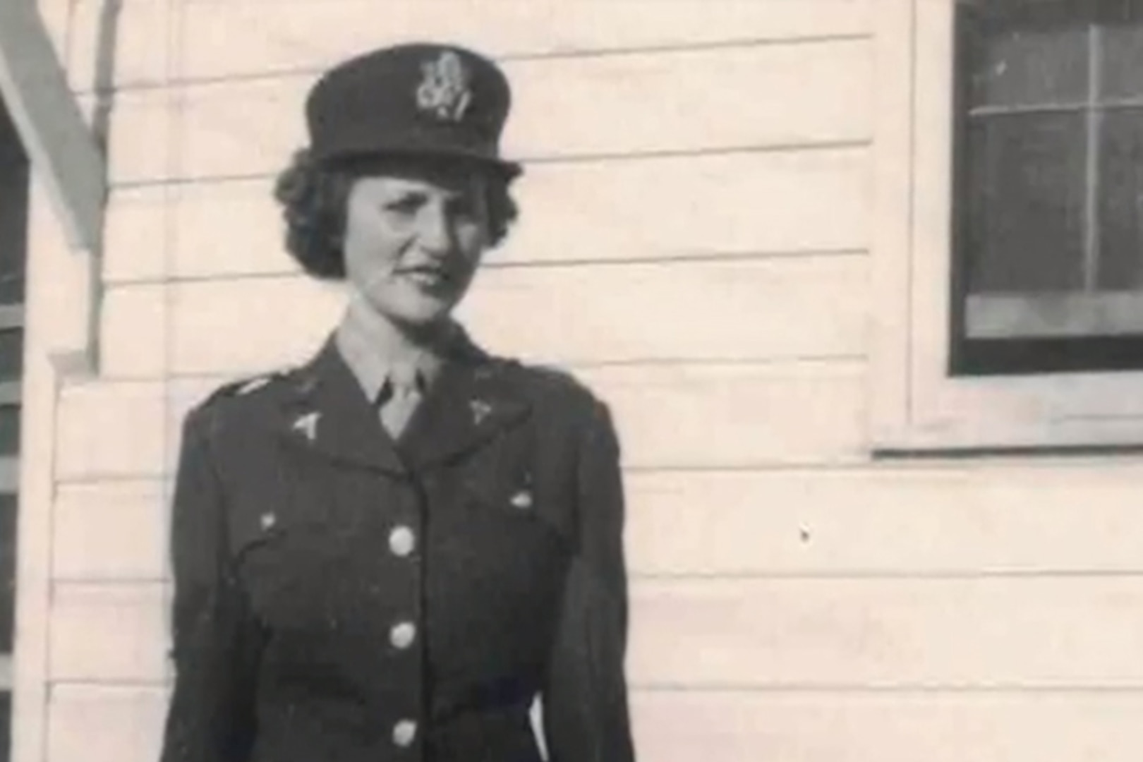 A woman wearing a military uniform poses for a photo.
